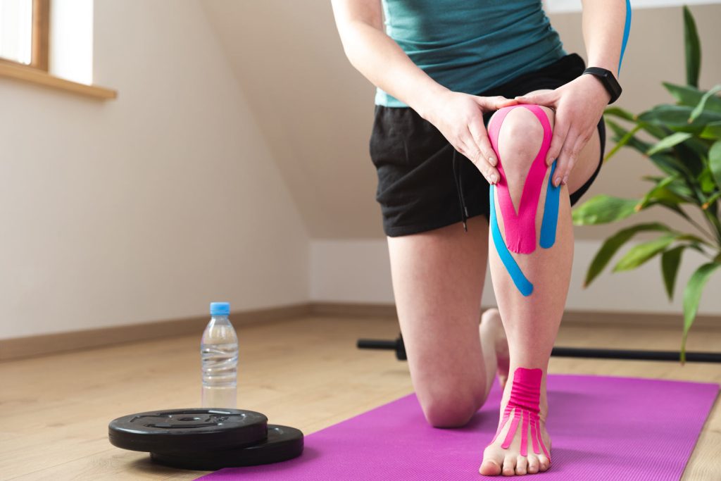 a people applying athletic tape on his leg