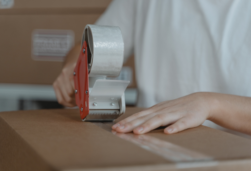a man applying packaging tape on carton