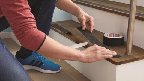 a man applying anti-slip tape on the staircases