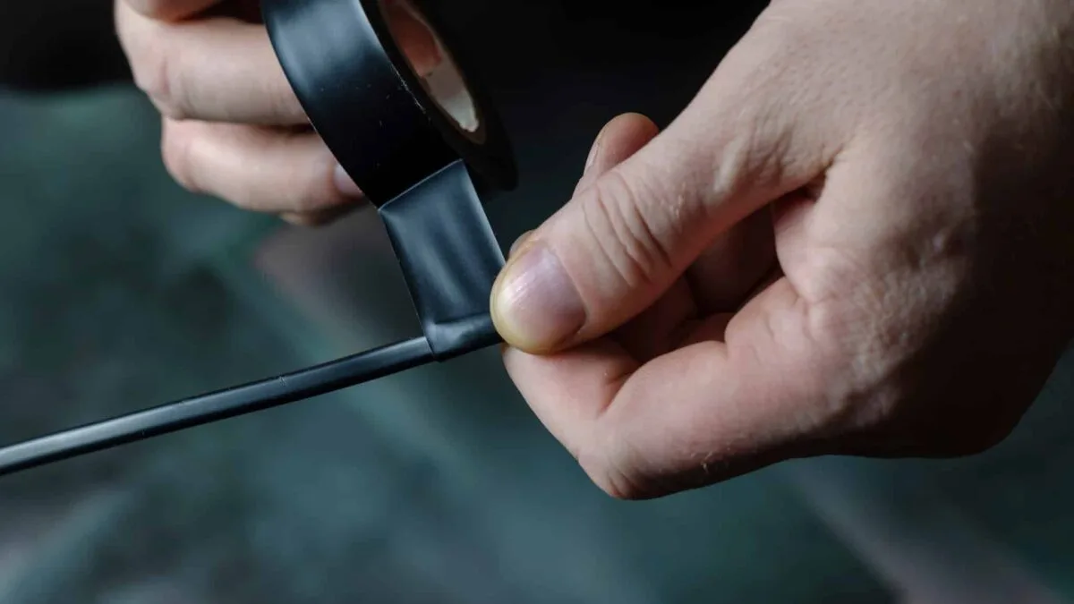 a people is using electrical tape to wrap the wires